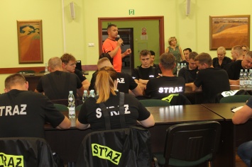 Strażacy siedzący na sali konferencyjnej